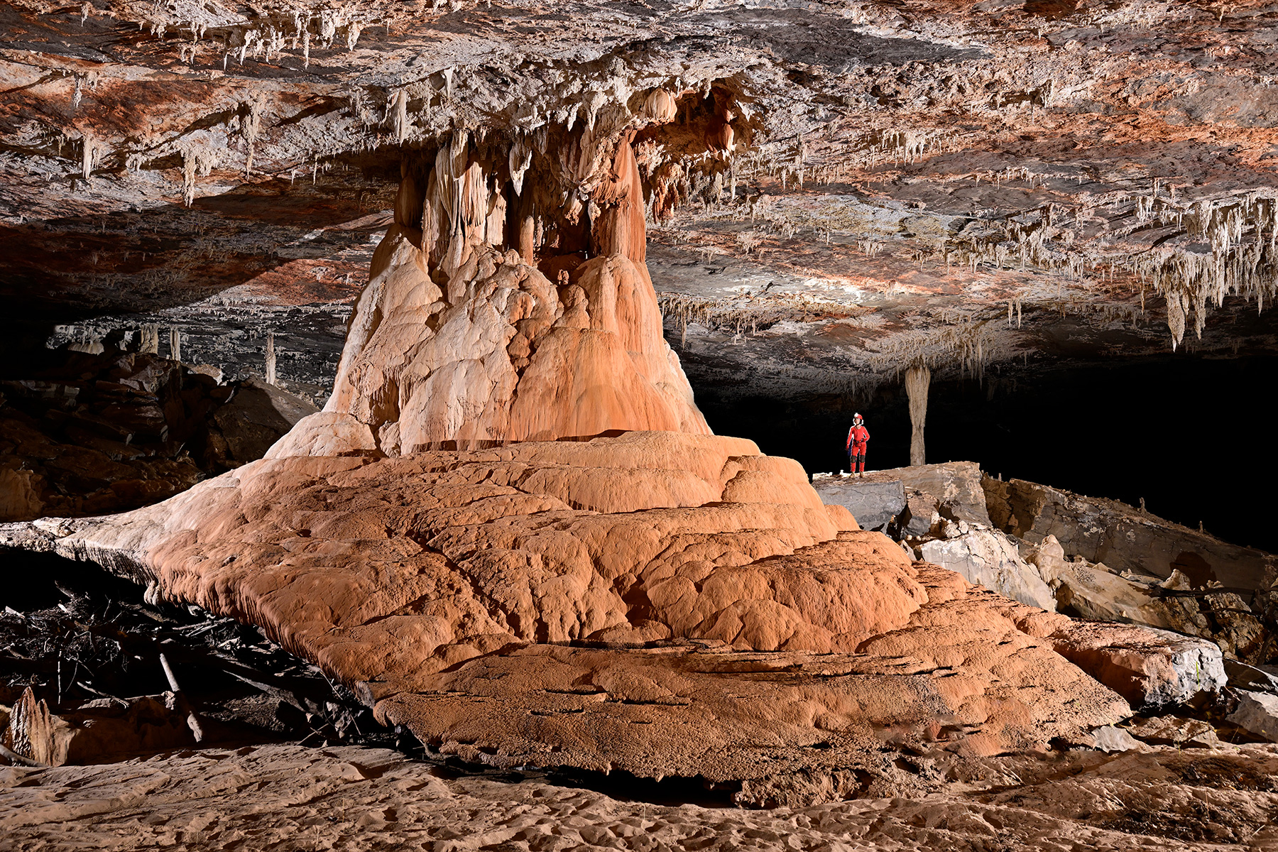 Caverna Angelica (Terra Ronca, Goias) - Massif  de coulées de calcite orange avec personnage en fond.